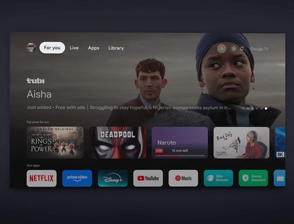 Vue de face d’un écran plat noir en verre affichant l’interface Google TV sombre avec barre d’onglets blancs, grande bannière de série et vignettes d’applications multicolores