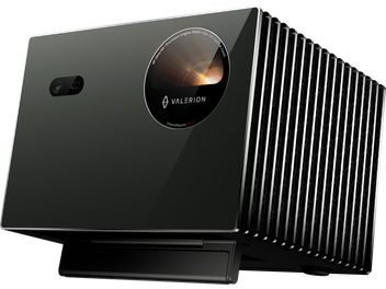 Valerion VisionMaster Pro 2 black video projector with glossy glass front panel, circular lens, and small sensor, right side with vertical metal fins, three-quarter front right view