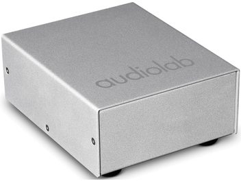 Conditionneur secteur Audiolab DC-BLOCK argent en vue oblique, boîtier rectangulaire argenté avec logo audiolab sur le dessus