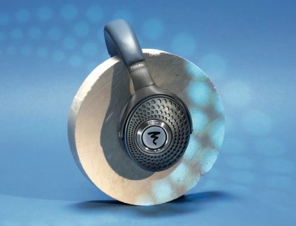 Casque audio noir et bois clair, vu de profil gauche, avec grille métallique ronde sur l'oreillette