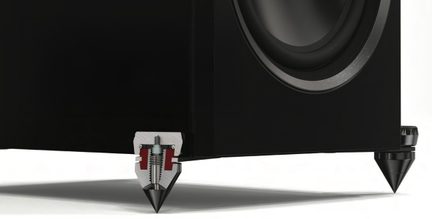 Vue rapprochée d'un caisson noir avec un haut-parleur circulaire et des pieds coniques métalliques sur une surface blanche