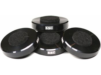 Four black rubber SSC Netpoint 100 vibration dampers, cylindrical in shape with a circular base, viewed from above