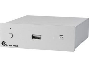 Δικτυακός αναπαραγωγέας ήχου Stream Box S2 σε ανοιχτό μεταλλικό χρώμα, μπροστινή όψη υπό γωνία, κυκλικό κουμπί στα αριστερά, κεντρική θύρα USB, κουμπί "Local" στα δεξιά.