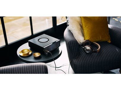 Préampli casque Naim Audio Uniti Atom Headphone Edition noir, vue de dessus avec deux tasses dorées, sur un canapé gris