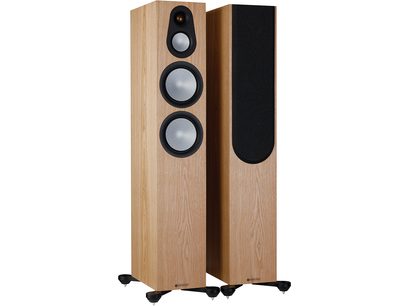 Due diffusori a colonna Monitor Audio Silver 300 7G in frassino, con tre altoparlanti rotondi neri sulla parte frontale in legno chiaro, visti di tre quarti