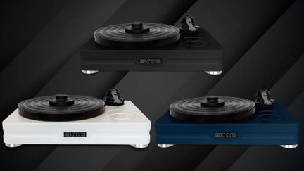 Tre pladespillere med rektangulær lakeret sokkel i sort, hvid og mørkeblå, sort rillet cirkulær pladetallerken, lige tonearm placeret på siden og cylindriske metalfødder, præsenteret set forfra i let fugleperspektiv