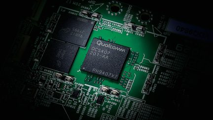 Vue rapprochée d'une carte électronique verte avec deux puces noires, l'une marquée "Qualcomm QCS407 201-AA PH9407X7"