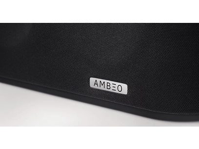 Dettaglio di una soundbar nera con il logo "AMBEO" in lettere bianche sulla griglia frontale in tessuto