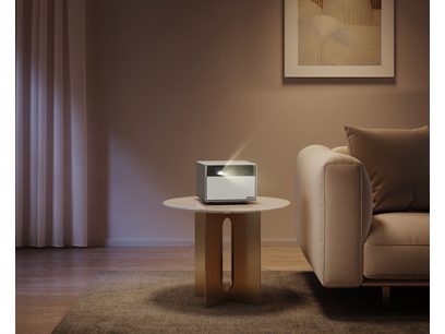 Vidéoprojecteur XGIMI Horizon Ultra posé sur une table basse en bois clair dans un salon aux murs beiges et canapé marron