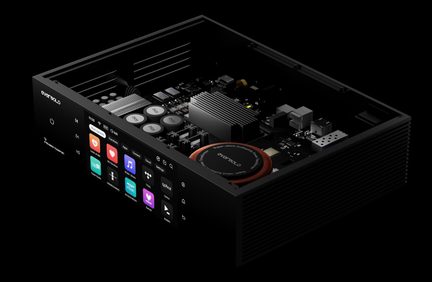 Black aluminum audio chassis, angled view, open cover, visible internal components including toroidal transformer, front panel with icon display