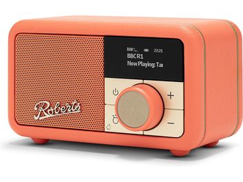 Radio Roberts Revival Petite 2 v oranžni barvi, ohišje iz umetne usnji, prednja stran z ujemajočo se prečno rešetko in logotipom, pravokotni črni digitalni zaslon, velika okrogla zlatobežna rumena vijačnica in štiri kvadratne tipke, pogled z desne sprednje strani.