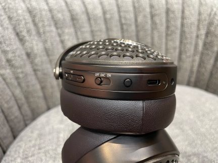 Czarne słuchawki z nausznicami ze skóry, perforowaną kratką, przyciskami sterującymi, portem USB-C i widocznym przełącznikiem w zbliżeniu