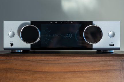 Srebrny wzmacniacz stereo Onkyo z dużym czarnym wyświetlaczem Bluetooth pokazującym głośność 40 i dwoma przednimi pokrętłami