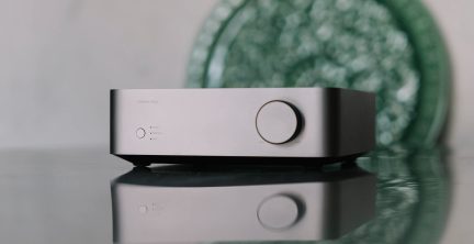 Rektangulärt silverfärgat hölje med en cirkulär knapp till höger, tre lysdioder och en knapp till vänster, reflekterande yta