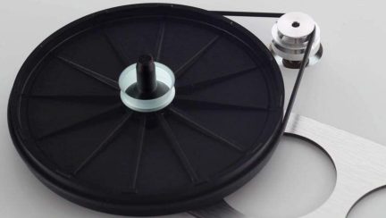 Giradischi in vinile nero con braccio di lettura metallico e contrappeso, su sfondo bianco
