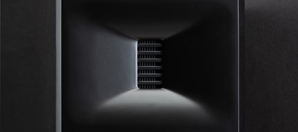 Une structure rectangulaire noire avec un intérieur conique et des grilles horizontales au centre