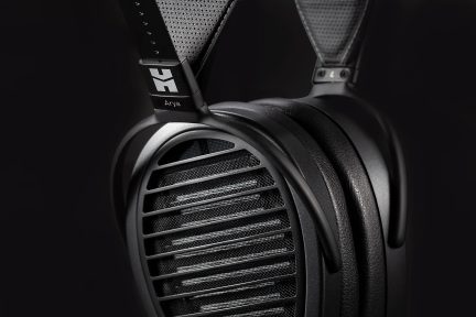 Un casque audio noir avec des grilles ovales, des coussinets épais et un bandeau texturé visible en gros plan