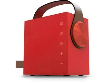 Enceinte bluetooth portable Morel Biggie rouge rubis en métal, vue trois-quarts avant en légère contre-plongée, cube lisse avec poignée arquée en cuir brun, large molette circulaire alu brossé sur le flanc droit et pictogrammes tactiles alignés verticalement sur la face avant