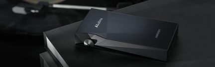 Player audio portabil negru mat cu suprafață texturată, buton rotativ argintiu și design unghiular, vedere în perspectivă
