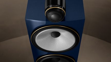 Enceinte bleue avec haut-parleur doré et argenté, vue de face en gros plan