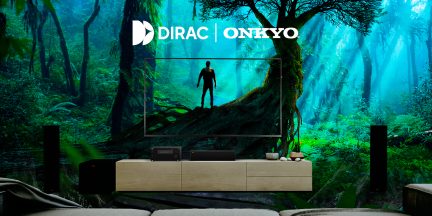 Front view, forest wall screen, human silhouette, light wood furniture, 2 black speakers, 2 electronic devices, 3 decorative objects