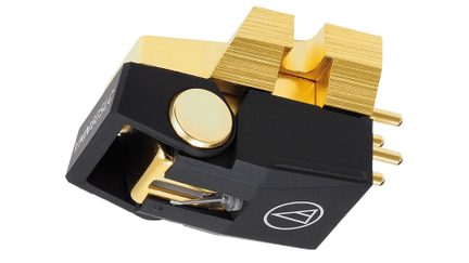 Vue rapprochée d'une cellule phono noire et dorée avec un logo blanc, des connecteurs dorés et une pointe visible