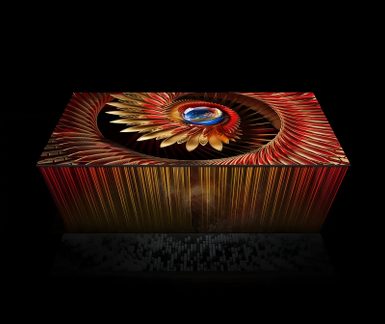 Grand écran plat rectangulaire noir à cadre métallique fin et surface vitrée, présenté en vue isométrique et affichant un motif fractal rouge et doré centré autour d’un orbe bleu