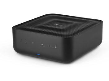 Ampli hi-fi stéréo Denon Home Amp, vue de trois quarts, boîtier noir, boutons tactiles numérotés 1 à 3, lecture/pause, volume moins et plus, indicateur lumineux bleu