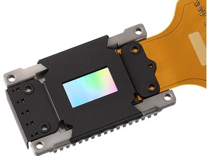 Capteur d'image DMD rectangulaire noir avec puce réfléchissante multicolore au centre, sur support jaune translucide