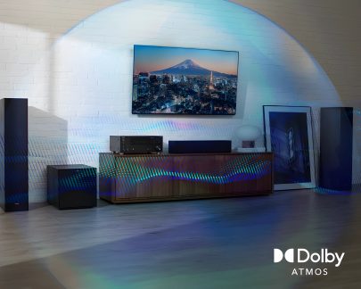 Modern living room with wall-mounted TV, wooden furniture, black speakers, amplifier, white lamp, leaning painting
