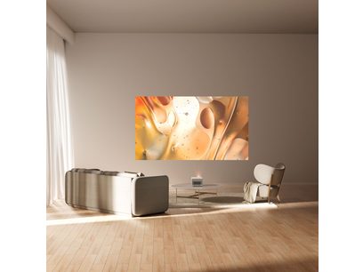 Toile abstraite orange et beige avec des formes organiques et des taches évoquant des bulles ou des cellules, dans un intérieur moderne avec canapé et fauteuil gris clair