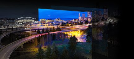 Vue nocturne d'une autoroute surélevée avec des lumières de circulation, des arbres et des bâtiments urbains en arrière-plan