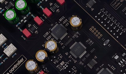 Circuit imprimé noir avec composants électroniques : puces, condensateurs rouges et verts, connecteurs dorés