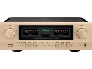 Amplificateur hi-fi intégré stéréo Accuphase E-3000 en aluminium champagne, vue de face, façade rectangulaire avec panneau central noir à deux vumètres rétroéclairés, gros sélecteurs ronds d’entrée et de volume latéraux, rangée inférieure de boutons et potentiomètres
