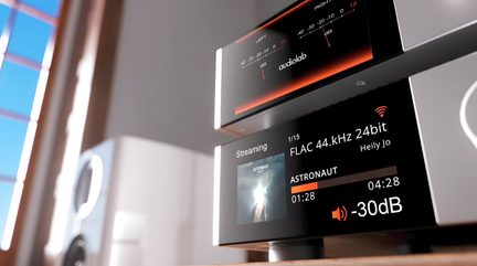 Un écran noir affiche des informations audio avec des textes blancs et orange, un graphique, une pochette d'album et un haut-parleur blanc flou à gauche