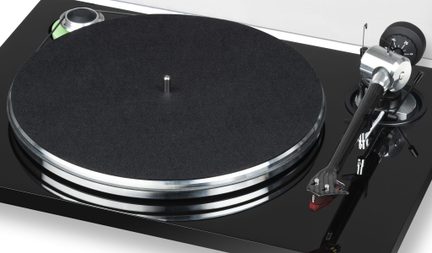Vue de dessus d'une platine vinyle avec plateau circulaire noir, bras de lecture argenté et noir, socle noir brillant