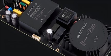 Composants électroniques noirs avec inscriptions blanches, connecteurs dorés et boutons sur une surface noire