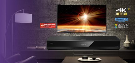 Melna metaliska Blu-ray atskaņotāja matēta apdare, skats no priekšas, plakans taisnstūra korpuss ar stikla frontāli un centrālo ciparu displeju