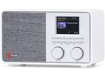 Pinell Supersound 201W bordradio i hvid plast med front delt mellem grå stofhøjttalergitter og børstet aluminiumpanel med farveskærm, rækker af knapper og to store drejeknapper, set fra højre forreste trekvartsvinkel