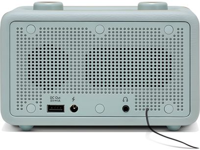 Vējš no priekšas Roberts Revival Rest galda radio ar debesszilas mākslīgās ādas apdari ar noapaļotiem stūriem, plašu centrālo perforētu metāla režģi un USB, barošanas un auskarnīcu pieslēgvietu rindu apakšā