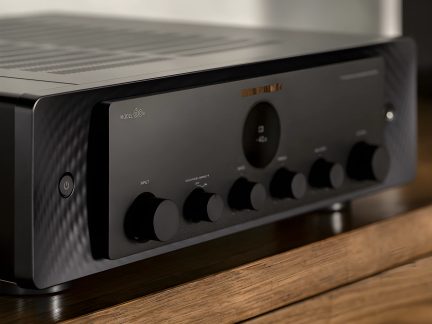 Amplificateur noir, vue de trois quarts, 6 boutons ronds en façade, bouton d'alimentation à gauche, surface texturée
