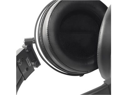 Gros plan intérieur d’un écouteur de casque noir en similicuir, tissu acoustique noir central et charnière métallique sombre visible du côté gauche