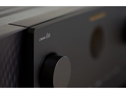Ampli home-cinéma Marantz Cinema 60 noir, vue rapprochée du coin supérieur gauche, logo blanc sur panneau noir mat