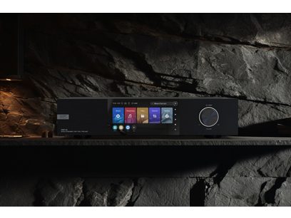 Lecteur audio réseau EverSolo DMP-A8 noir posé sur une roche dans une grotte, écran allumé affichant le menu principal