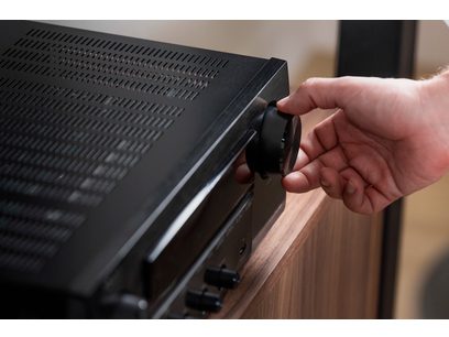 Main tenant bouton de réglage sur panneau avant en métal brossé d'un amplificateur hi-fi stéréo Denon DRA-900H noir