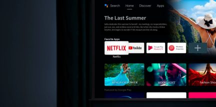 schermo piatto nero, interfaccia smart TV visualizzata, applicazioni e immagini colorate, testo bianco su sfondo nero, vista parziale frontale, bordi sottili