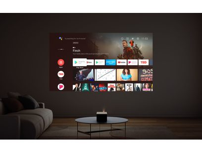 Vidéoprojecteur XGIMI Horizon Ultra projetant une interface utilisateur Android TV sur un mur dans un salon avec canapé