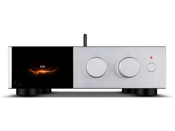 Audiolab D9 silver audio converter, front view, brushed aluminum casing with a black glass left panel displaying an orange glow, two large circular selection and volume knobs, small power button with red LED, and visible rear vertical antenna