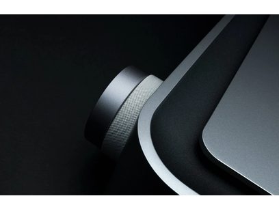 Primo piano ravvicinato sulle curve metalliche argentate e nere lucide di un dispositivo elettronico