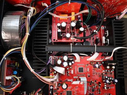 Ampli hi-fi stéréo Advance Paris A10 noir, vue intérieure montrant circuits imprimés rouges avec composants électroniques